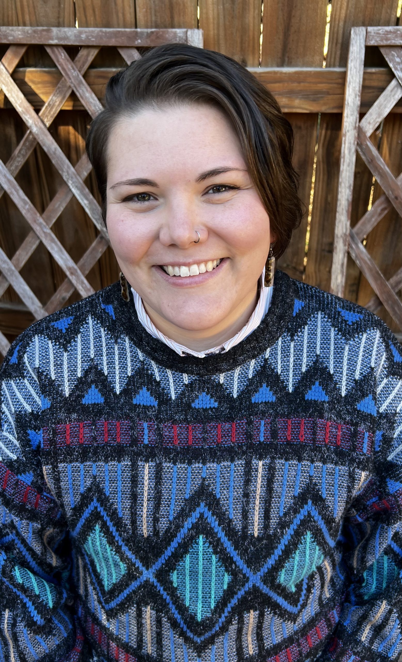Tara, smiling in a geometric-pattern sweater.